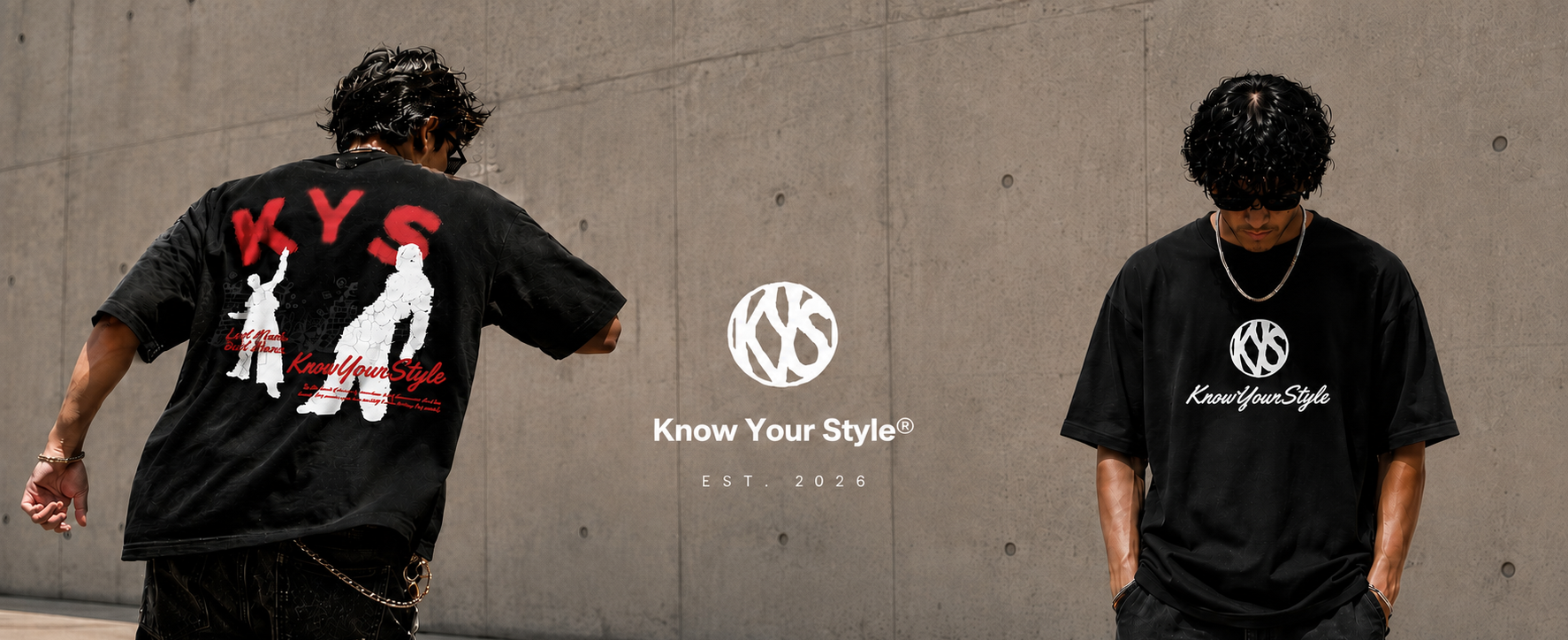 Two models wearing black KYS (Know Your Style) t-shirts in an outdoor urban setting against a concrete wall. One model is shown from the back wearing a black t-shirt with a red and white graphic print, and the other is shown from the front wearing a black t-shirt with a white KYS logo on the chest.